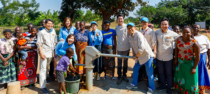 670x300_Day5_02_NuSkin Nu Skin sales leaders and employees pose for a picture with locals from the village of Kasiya as they dedicate a new borehole water well to their village.