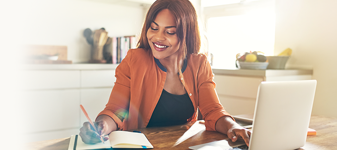 V1_Dont-Be-Afraid-of-Failure_Innovation_compressed Woman writes in a notebook while looking at something on her laptop.